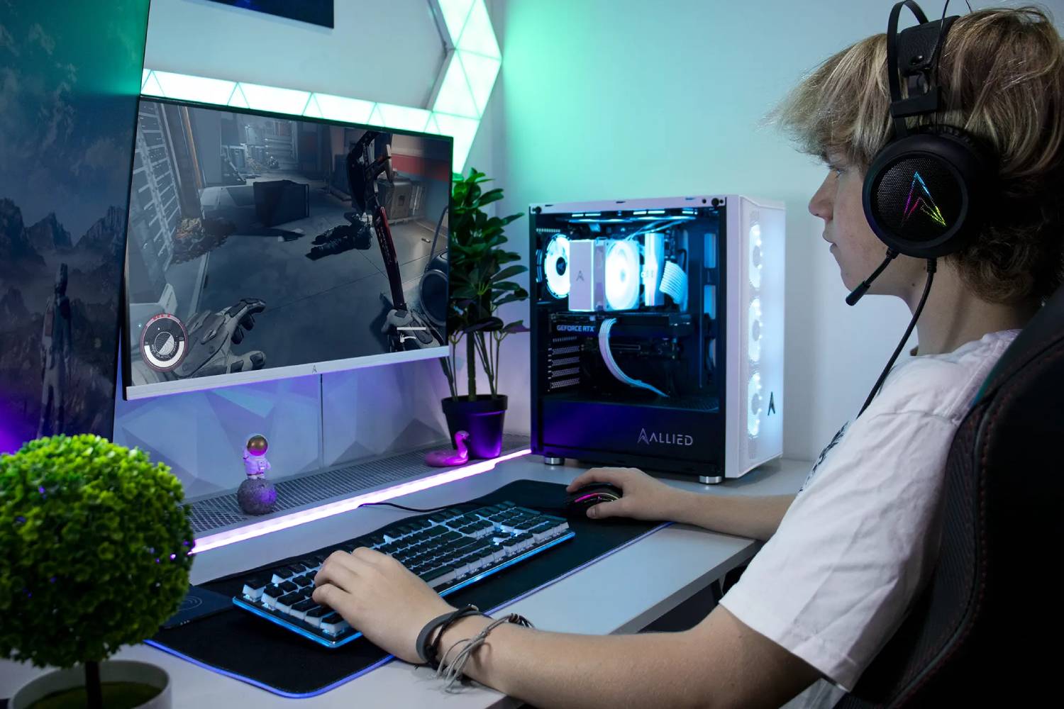 A gamer uses a keyboard and mouse, focused on a screen displaying a video game, with a stylish gaming PC and plants nearby.