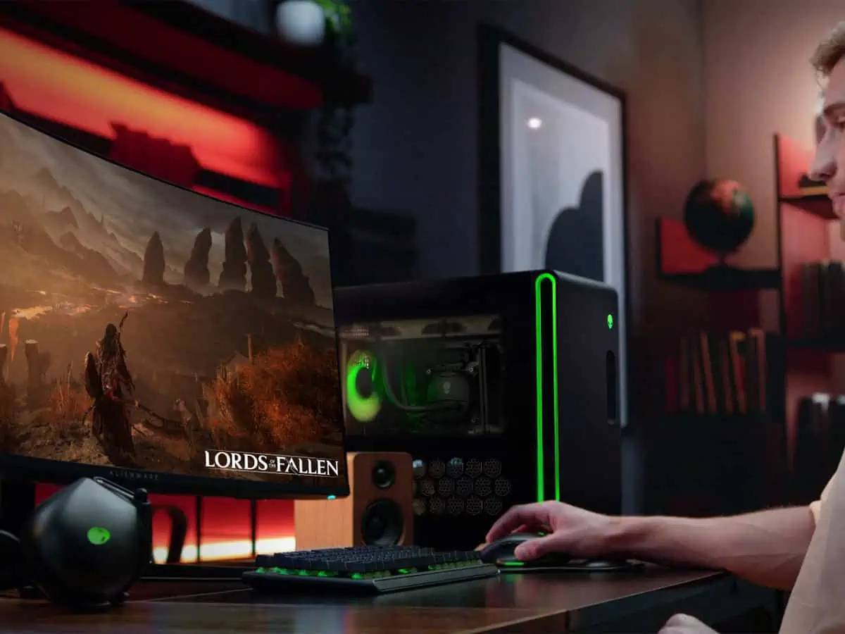 A gamer focuses on a curved monitor displaying Lords of the Fallen in a vibrant gaming setup with ambient lighting.