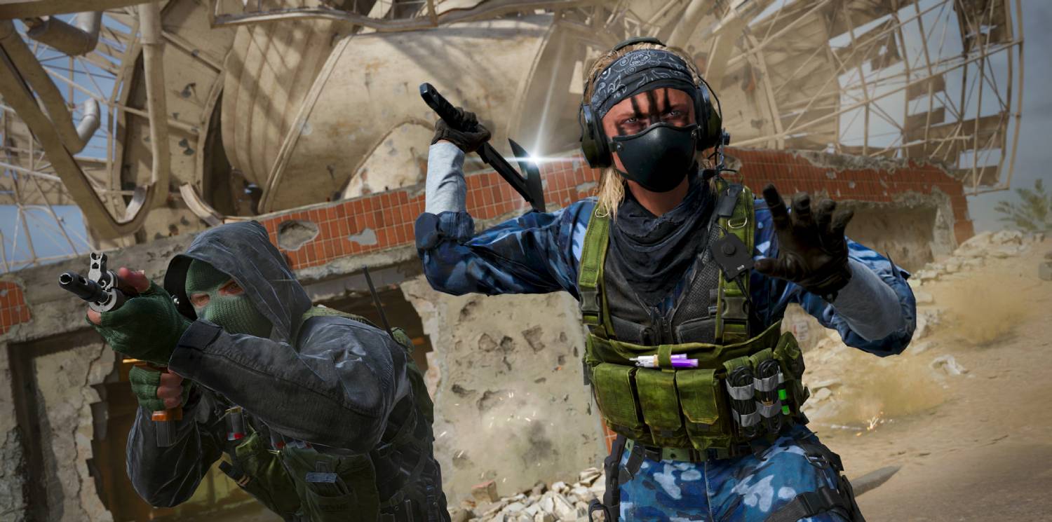 A tactical scene with two armed characters: one wearing a green ski mask and the other in blue camo, set against a destroyed building.