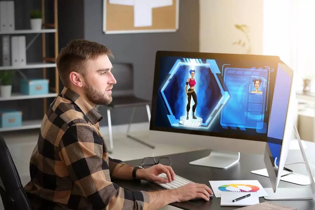 A person sitting at a desk, engaged in a video game on a computer screen, displaying a character in a futuristic setting.