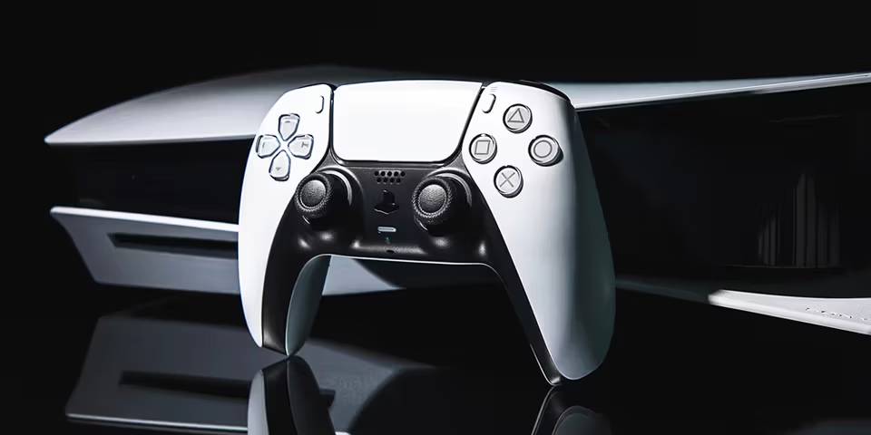 A close-up of a white PlayStation 5 console and its DualSense controller, showcasing sleek design against a dark background.