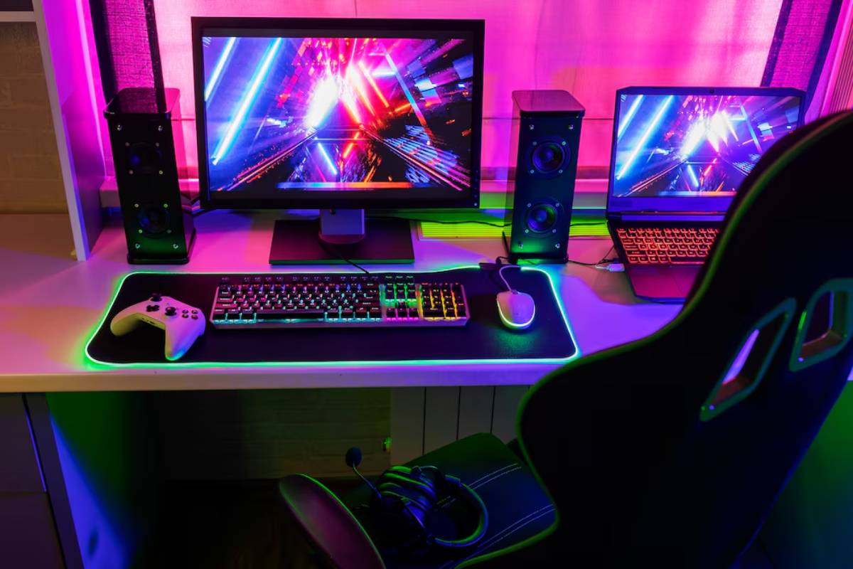 A vibrant gaming setup with multiple screens, neon lights, and a gaming chair.