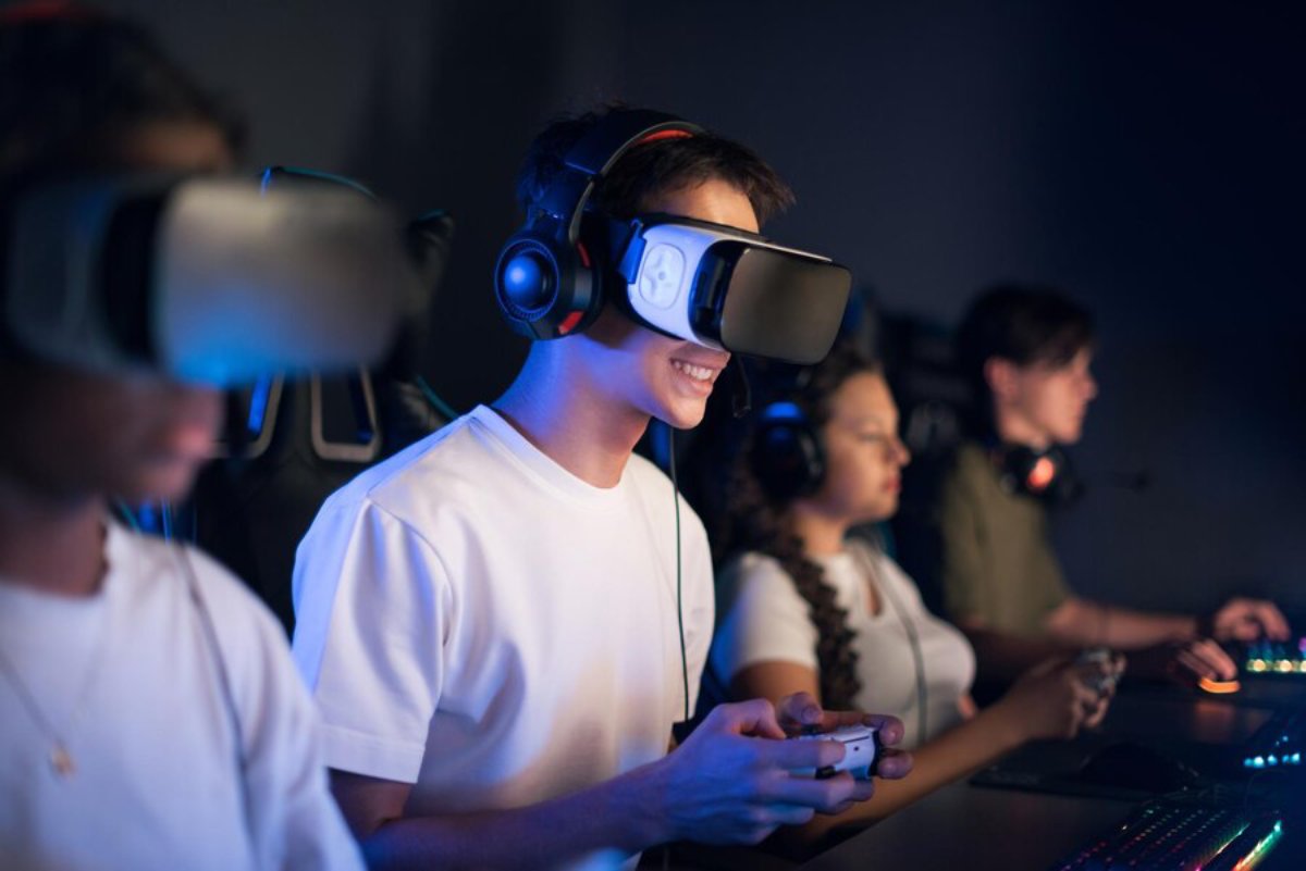 Young adults wearing VR headsets and using controllers, focused on gaming in a dark, modern room.
