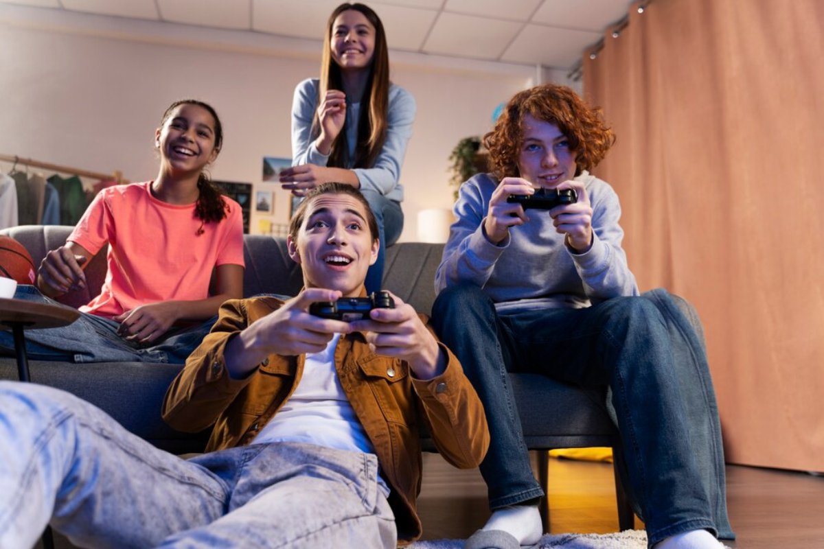 Four teenagers enjoying video games in a cozy living room, showing excitement and focus.
