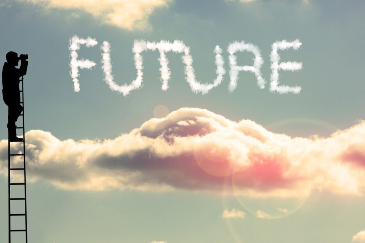 Person on a ladder looking through binoculars at FUTURE written in cloud letters against a sunset sky.